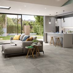 a living room filled with furniture next to a kitchen