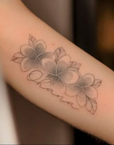 a woman's arm with flowers on it and leaves around the wrist tattoo design