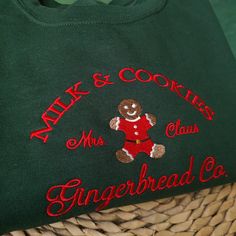 a green sweater with an embroidered gingerbread co bear on the front and red letters across the chest