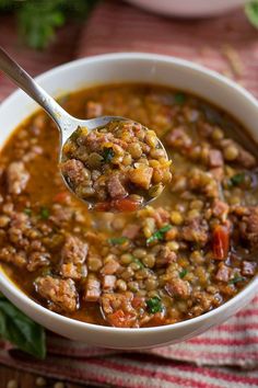 a spoon full of soup with meat and vegetables