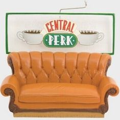 an orange leather couch sitting in front of a central perk sign