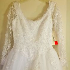 a white wedding dress hanging on a hanger