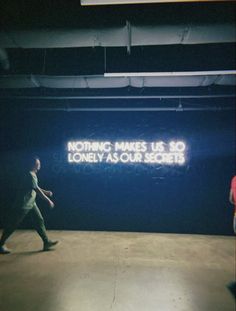 a man walking past a neon sign that reads nothing makes us so lonely as our secrets