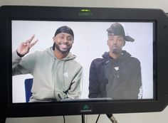 two young men are on a television screen