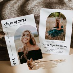 two graduation announcement cards sitting on top of a table