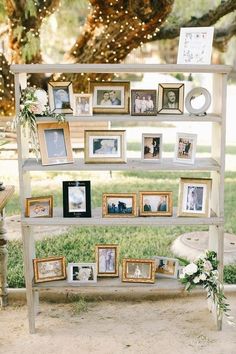 an old book shelf with pictures and flowers on it