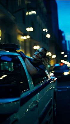 a man is sitting in the back of a police car at night with his eyes closed