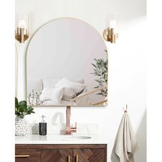 a bathroom vanity with a mirror above it and a towel hanging on the wall next to it