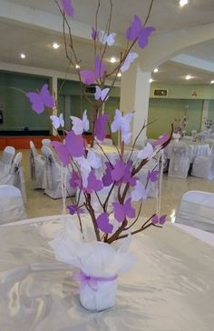 a vase filled with purple and white flowers on top of a table covered in tables cloths