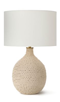 a white table lamp sitting on top of a wooden table next to a white lampshade