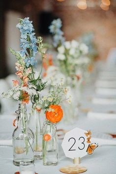 there are many vases with flowers in them on the table at this wedding reception