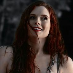 a woman with red hair and makeup is posing for the camera