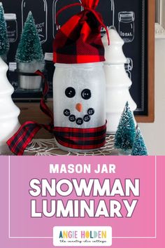 mason jar snowman luminary with christmas trees in the background and text overlay reading mason jar snowman lummary