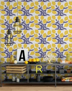 a yellow and blue wallpaper with lemons on the side table next to it