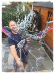 a man standing next to a metal sculpture