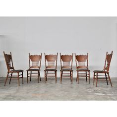 six wooden chairs are lined up in a row