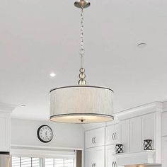 a kitchen with white cabinets and a large chandelier