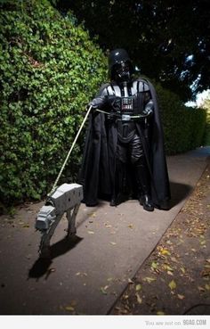 a man dressed as darth vader walking down a street