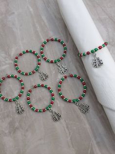 four bracelets with charms on them sitting next to a napkin