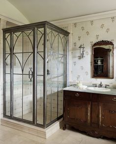 a bathroom with an enclosed shower next to a sink