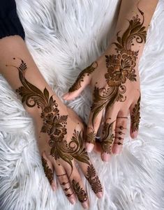 two hands with henna tattoos on them