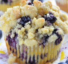 a muffin with blueberries and crumbs on it sitting on a plate