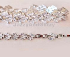 This high-end cubic zirconium bracelet shines like a natural diamond. You will treasure this baguette Cubic Zirconium bracelet as a family heirloom to wear for many years to come. ● Trapezoid shape cubic zirconium on high-polish silver-plated copper ● 6.69" long + 0.78" extender if you need a more extended size ● Matching stud earrings 2.3 cm about an inch in diameter ● Dangle earrings also feature high-quality Cubic Zirconium and ivory simulated pearls measuring 1.4" long. HELP & ADVICE Styling Silver Baguette Jewelry For Wedding, Dazzling Baguette Cut Diamond Bracelet For Wedding, Wedding Jewelry With Baguette Diamonds And Crystal, Silver Baguette Diamond Bracelet For Wedding, Silver Baguette Bracelet For Formal Occasions, Wedding Tennis Bracelet With Baguette Cubic Zirconia, Elegant Baguette Bracelets For Wedding, Dazzling Baguette Cut Bracelet For Wedding, Elegant Wedding Bracelets With Baguette Shape