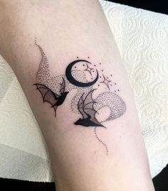 a black and white photo of a tattoo design on the left arm with bats flying around it