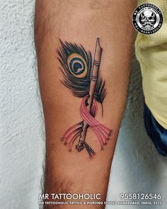 a tattoo on the arm of a person with a pink ribbon and a feather in it