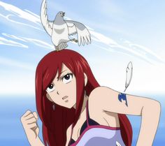 a woman with red hair and a bird on her head is standing in front of the ocean