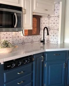 a kitchen with blue cabinets and white countertops is seen in this image from the front view