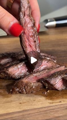 a woman is placing a piece of steak on top of it