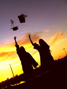 two girls are throwing their hats in the air at sunset with one girl wearing a graduation cap and gown