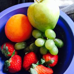 a blue bowl filled with lots of fruit