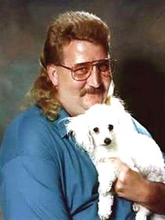 a man holding a white dog in his arms