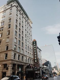 a tall building sitting on the side of a street next to traffic lights and people