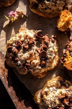 cookies with chocolate chips and nuts are on an old baking sheet, ready to be eaten