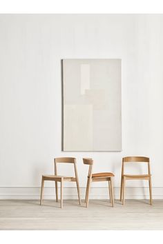 three chairs in front of a painting on the wall