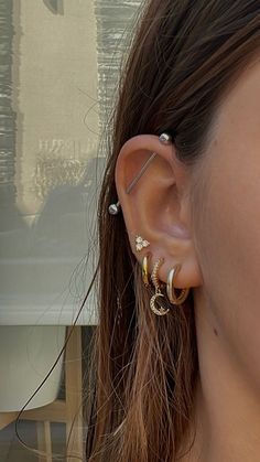 a close up of a person with ear piercings on their ears and wearing an earring