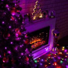 a christmas tree is lit up with purple lights