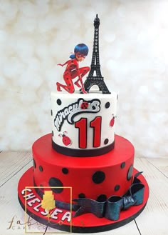 a red and black cake with the eiffel tower in the background