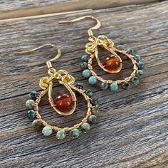 a pair of earrings sitting on top of a wooden table