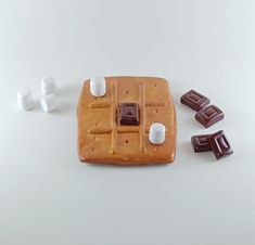 some marshmallows and chocolate on a white table