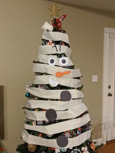 a christmas tree made out of wrapping paper with an angry snowman on the top