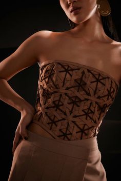 Strapless bodice top combining the classic sophistication of bustier-inspired seams and form-fitting top stitching finish this exquisite geometric weaved corset in shades of brown. The suede semi-sheer top features a bandeau neckline and is crafted entirely in a diamond weave pattern. More structure has been added with the help of boning on the front and back. Pair this stunning piece with high-waist faux leather pants and pumps to stimulate the overall appearance.Model wears a size small / Bust Formal Suits For Women, Sheer Pants, Form Fitting Tops, Pleated Jumpsuit, Semi Sheer Top, Bodice Top, Diamond Weave, Backless Top, Weave Pattern