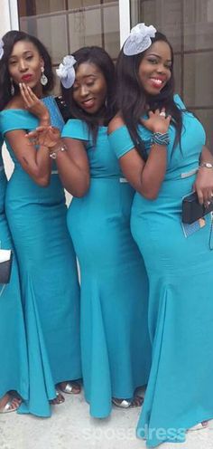 three women in blue dresses posing for the camera with their hands up and one woman holding her