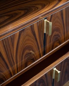 two wooden drawers with brass handles on each drawer and wood grained surface in the background