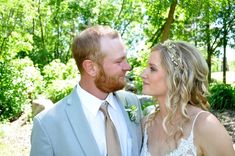 a bride and groom pose for a photo in front of the trees at their wedding