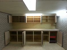 an empty room with shelves, cabinets and a red chair in the middle of it