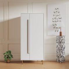 a white cabinet sitting in the middle of a room next to a potted plant